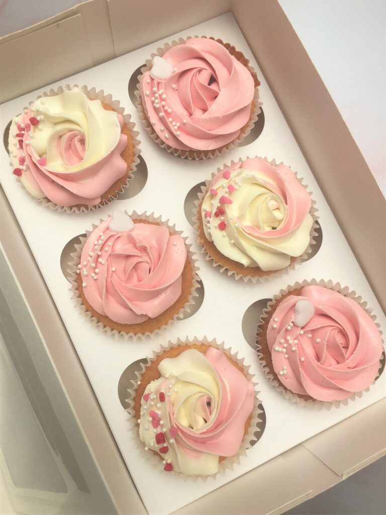 Elegantly decorated cupcakes with floral designs and sprinkles