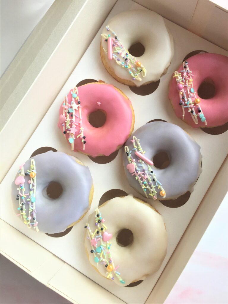 Soft baked doughnuts, glazed and covered in sprinkles