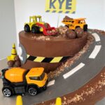 Digger Cake decorated with crushed biscuits and chocolate for a sand/mud effect and chocolate boulders