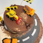 Digger Cake decorated with crushed biscuits and chocolate for a sand/mud effect and chocolate boulders