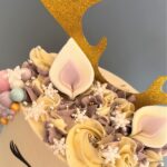 Reindeer Cake decorated with edible snowflakes and pearlised chocolate baubles and swirls of smooth buttercream