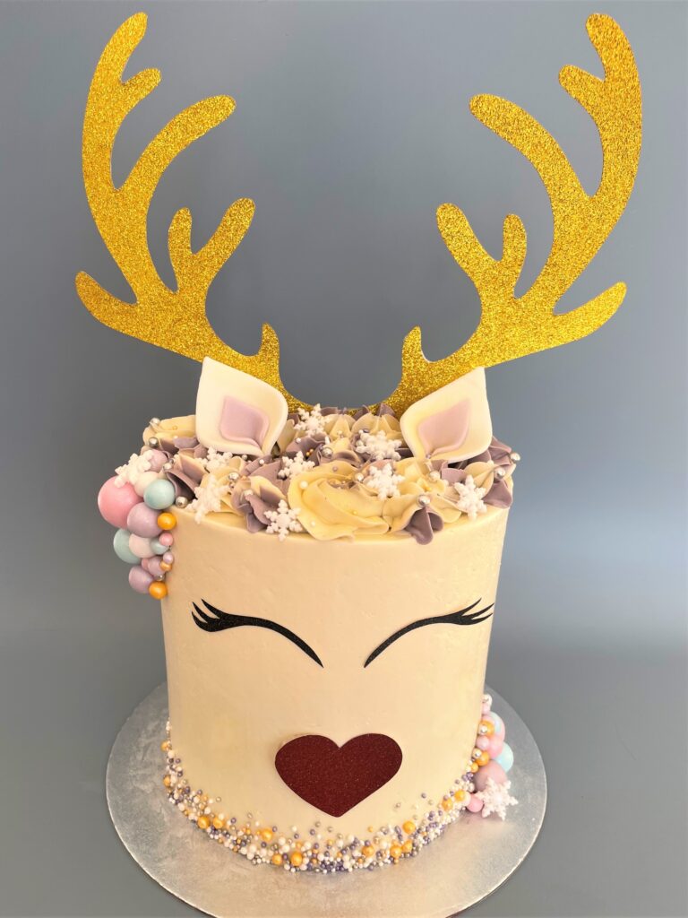 Reindeer Cake decorated with edible snowflakes and pearlised chocolate baubles and swirls of smooth buttercream