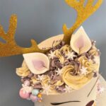 Reindeer Cake decorated with edible snowflakes and pearlised chocolate baubles and swirls of smooth buttercream