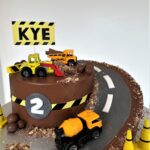 Digger Cake decorated with crushed biscuits and chocolate for a sand/mud effect and chocolate boulders