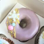 Festive iced doughnut with snowflake and bauble sprinkles