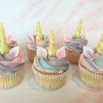 Unicorn cupcake with edible ears and horn and a swirl of magical swiss meringue buttercream