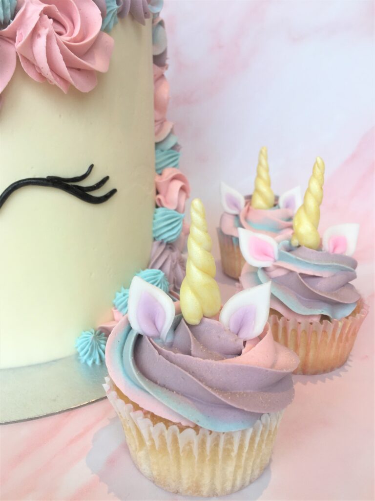 Unicorn cupcake with edible ears and horn and a swirl of magical swiss meringue buttercream