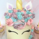 Unicorn cake with swirls of colourful buttercream and edible fondant ears and horn