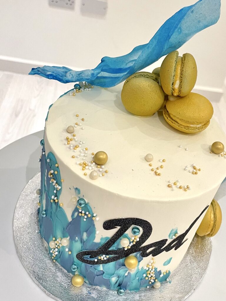 Abstract decorated cake with macarons and wafer paper sail