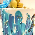 Abstract decorated cake with macarons and wafer paper sail