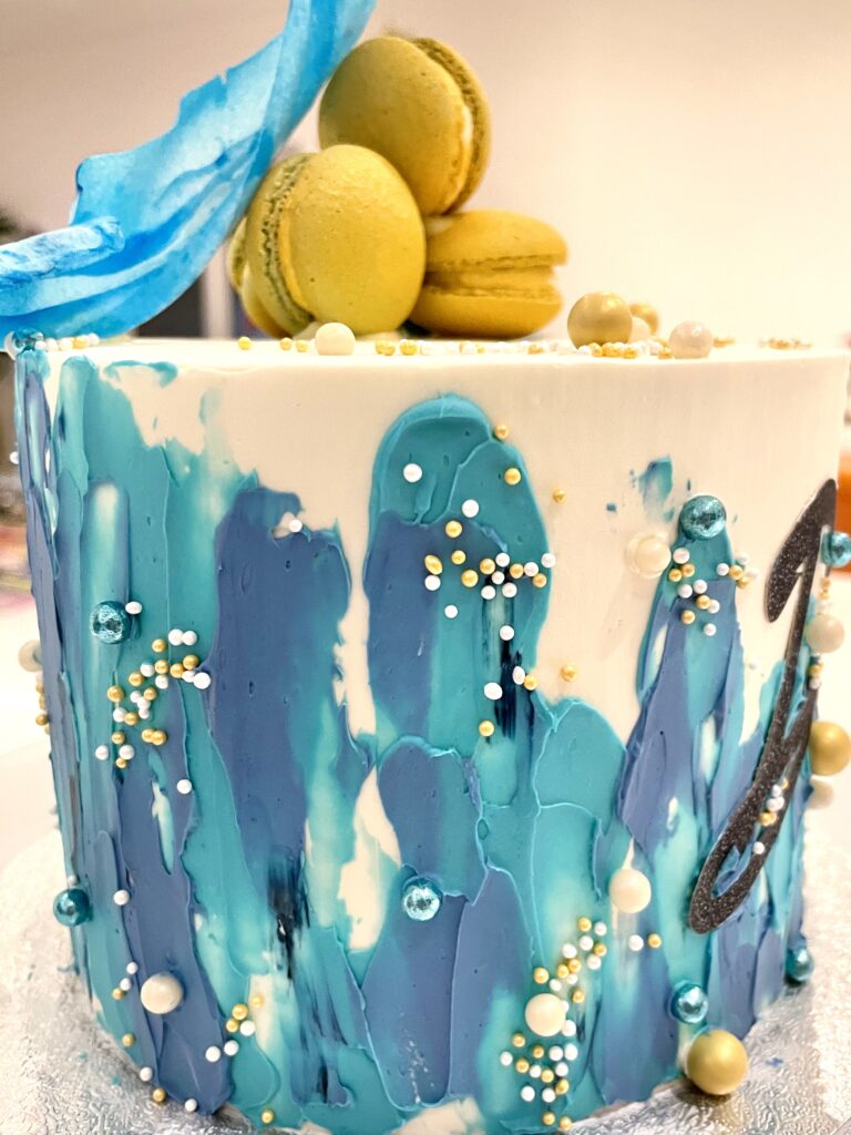 Abstract decorated cake with macarons and wafer paper sail