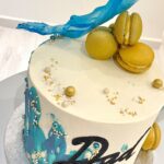 Abstract decorated cake with macarons and wafer paper sail