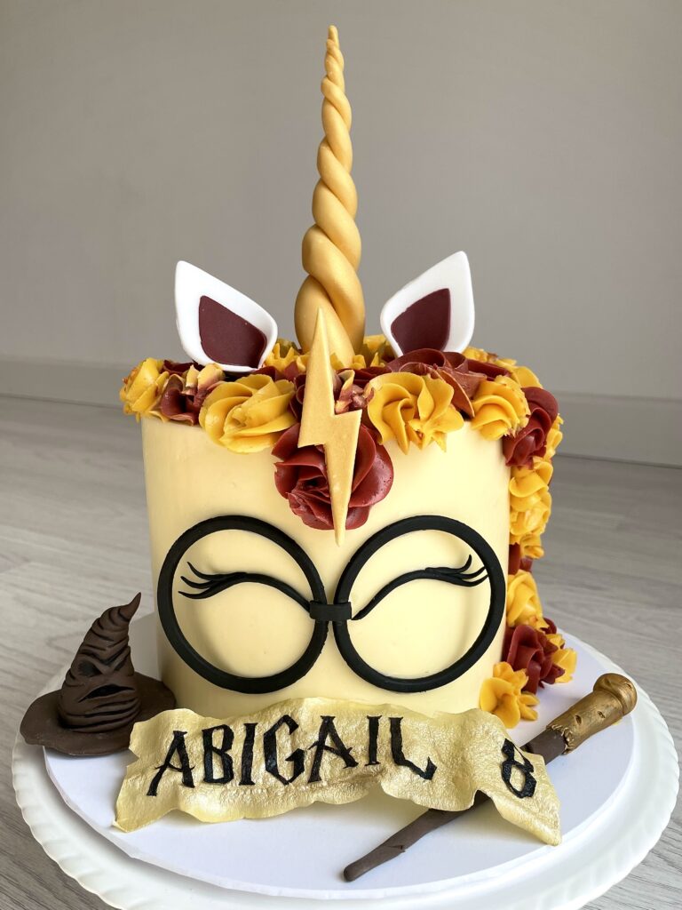 When Harry met a unicorn! Similar design to our classic unicorn cake but with HP glasses and accessories. With wafer paper name and age sign.